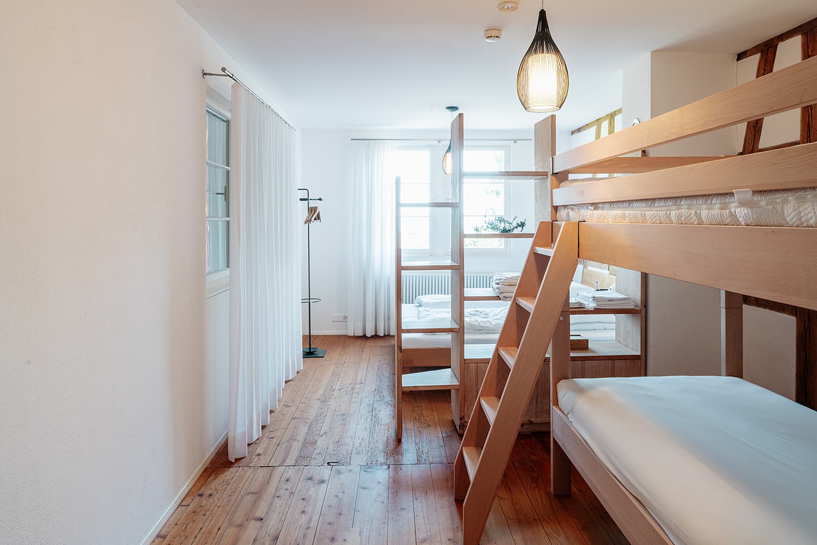 Mehrbettzimmer mit Etagenbett und Fenster
