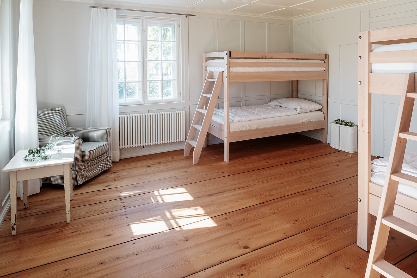 Helles Gästezimmer mit Holzboden und Etagenbett